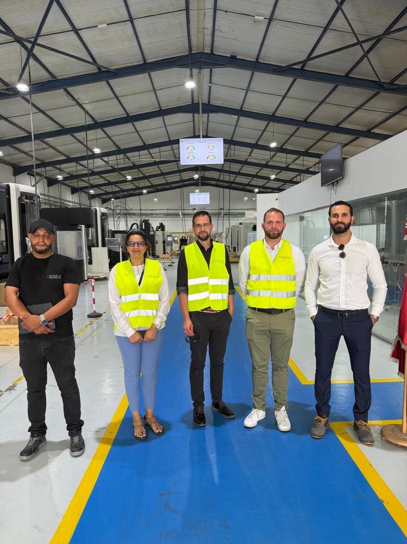The visitors and their ESM hosts on the machining floor.
